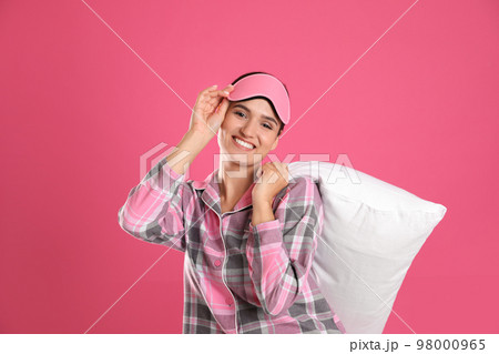 Beautiful woman with pillow on pink background. Bedtime 98000965
