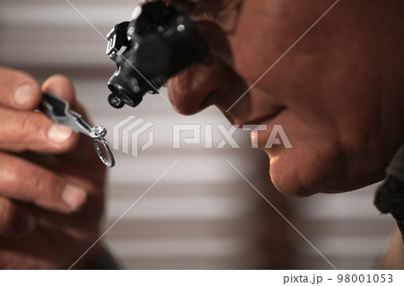 Professional jeweler working with beautiful ring indoors, closeup 98001053