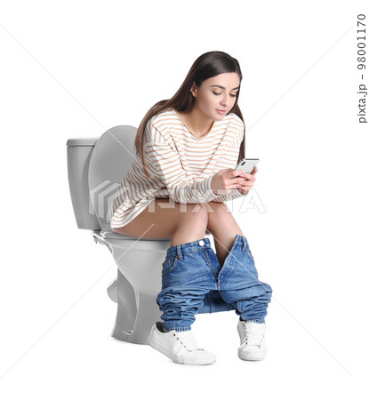 Woman with smartphone sitting on toilet bowl, white background 98001170