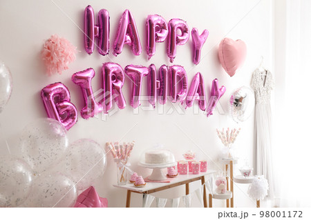 Phrase HAPPY BIRTHDAY made of pink balloon letters in decorated room 98001172