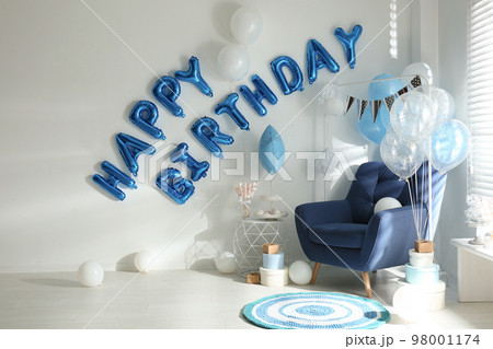 Phrase HAPPY BIRTHDAY made of blue balloon letters in decorated room 98001174