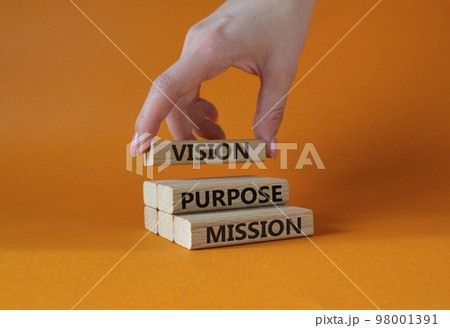 Vision Purpose Mission symbol. Concept word Vision Purpose Mission on wooden blocks. Beautiful orange background. Businessman hand. Business and Vision Purpose Mission concept. Copy space. Vision Purpose Mission symbol. Concept word Vision Purpose Mission on wooden blocks. Beautiful orange background. Businessman hand. Business and Vision Purpose Mission concept. Copy space. 98001391