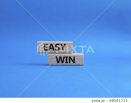 Easy win symbol. Wooden blocks with words 'Easy win'. Beautiful blue background. Business and 'Easy win' concept. Copy space. Easy win symbol. Wooden blocks with words 'Easy win'. Beautiful blue background. Business and 'Easy win' concept. Copy space. 98001715
