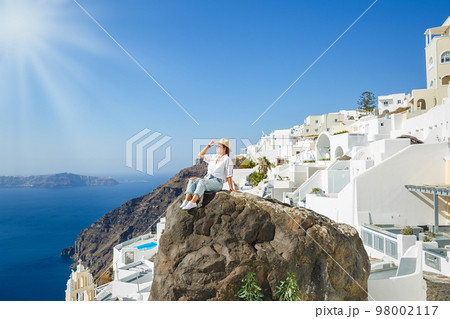 Young woman on a high cliff above the sea Young woman on a high cliff above the sea 98002117