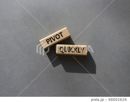 Pivot quickly symbol. Wooden blocks with words Pivot quickly. Beautiful grey background. Business and Pivot quickly concept. Copy space. 98002626