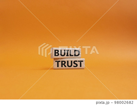 Build trust symbol. Wooden blocks with words Build trust. Beautiful orange background. Business and Build trust concept. Copy space. Build trust symbol. Wooden blocks with words Build trust. Beautiful orange background. Business and Build trust concept. Copy space. 98002682