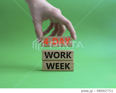 4-day work week symbol. Concept words 4-day work week on wooden blocks. Beautiful green background. Businessman hand. Business and 4-day work week concept. Copy space 98002751