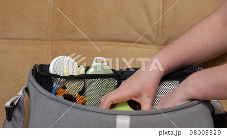 Person prepares big bag for walking to park with baby 98003329