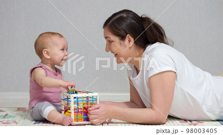 Mother plays toys with excited baby girl and enjoys weekend 98003405