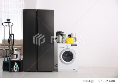 Refrigerator and different household appliances in room. Space for text Refrigerator and different household appliances in room. Space for text 98003600
