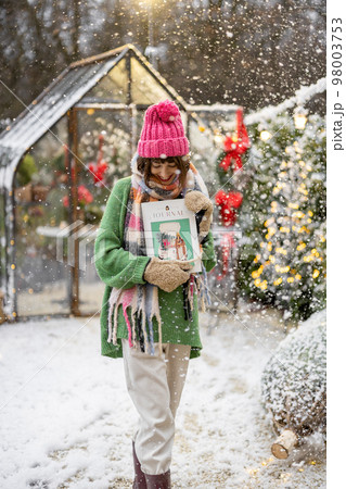 Woman at backyard on winter holidays Woman at backyard on winter holidays 98003753