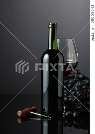 Red wine and blue grapes on a black background. Red wine and blue grapes on a black background. 98005042