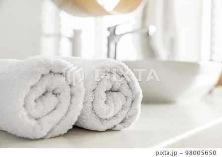 Clean rolled towels on countertop in bathroom Clean rolled towels on countertop in bathroom 98005650