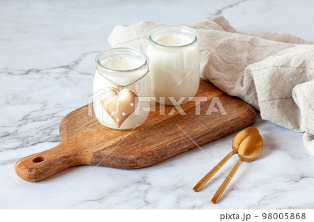 Two portions of joghurt, served on a cutting board, Valentine day breakfast idea 98005868