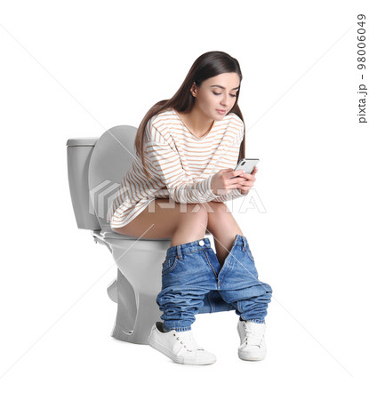 Woman with smartphone sitting on toilet bowl, white background 98006049