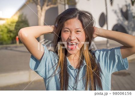 Portrait of a beautiful asian woman smiling and looking at camera outdoors 98006156