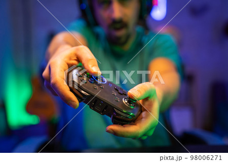 Modern gamer plays video games with gamepad on a technological room entertainment, cyberspace. 98006271