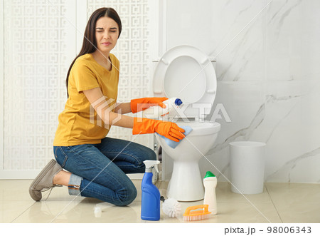Young woman feeling disgust while cleaning Young woman feeling disgust while cleaning 98006343