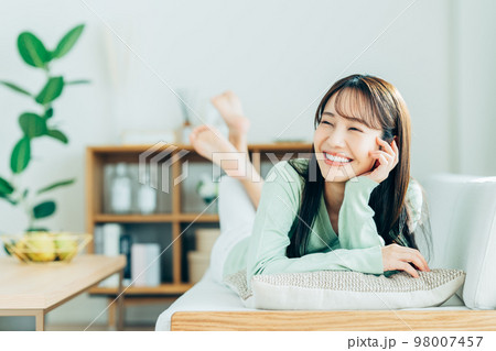 リビングでくつろぐ若い女性 リビングでくつろぐ若い女性 98007457