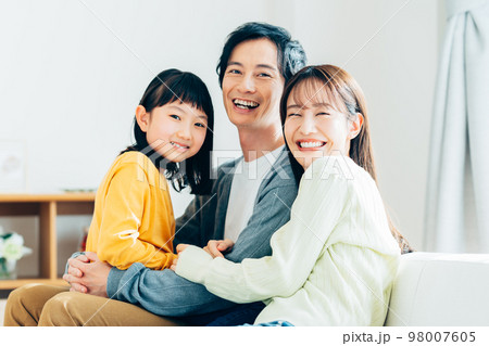 リビングでくつろぐ若い家族 98007605