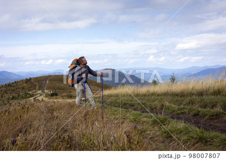 tourist with a backpack on the background of the mountains tourist with a backpack on the background of the mountains 98007807