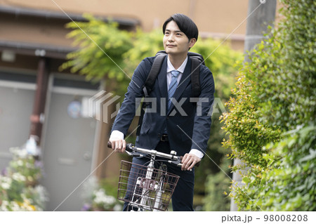 自転車に乗ったスーツ姿の若い男性 98008208
