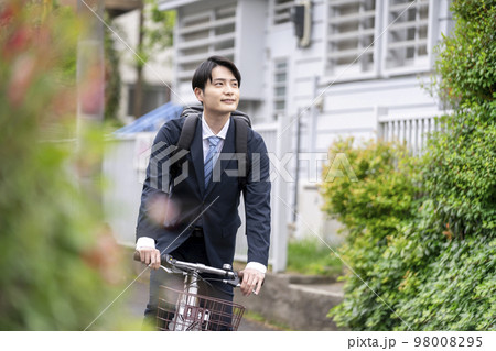 自転車に乗ったスーツ姿の若い男性 98008295