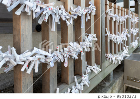 神社の境内に設置されているみくじ掛に結ばれたおみくじ 神社の境内に設置されているみくじ掛に結ばれたおみくじ 98010273