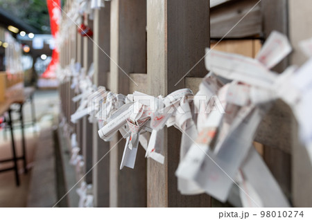 神社の境内に設置されているみくじ掛に結ばれたおみくじ 神社の境内に設置されているみくじ掛に結ばれたおみくじ 98010274