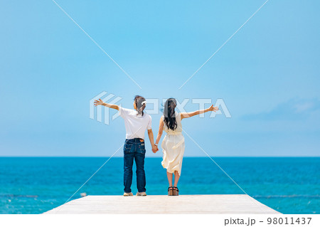 海の桟橋に立つ女性たち 98011437