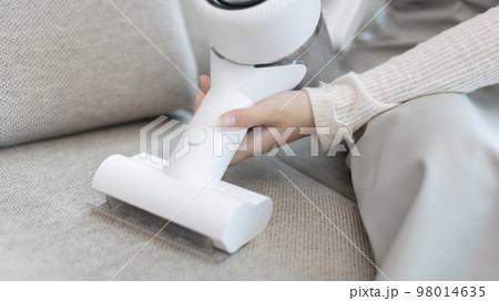 Woman vacuuming the floor of her living room, Big cleaning in the house, Removes germs and dirt and deep stains, Housewife cleaning, Keeping her home clean, Domestic hygiene. Woman vacuuming the floor of her living room, Big cleaning in the house, Removes germs and dirt and deep stains, Housewife cleaning, Keeping her home clean, Domestic hygiene. 98014635