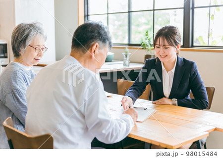 高齢者夫婦にプランを説明する司法書士・税理士・ソーシャルワーカー・社会福祉士の女性 98015484