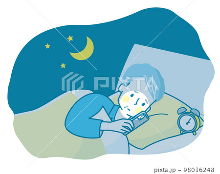 夜ベッドの中でスマホを見る不安な顔のシニア男性 98016248