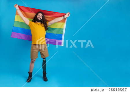 Happy man with a prosthetic leg waving a lgbt flag 98016367