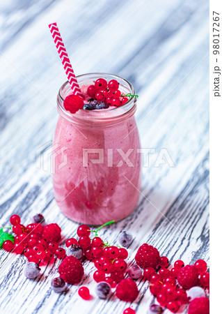 From above view of berries milkshake which made from raspberry, blueberries, currant in glass jar From above view of berries milkshake which made from raspberry, blueberries, currant in glass jar 98017267
