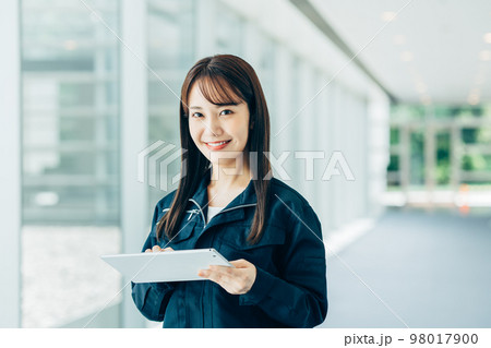 タブレットを持って作業をする若い女性の作業員 98017900