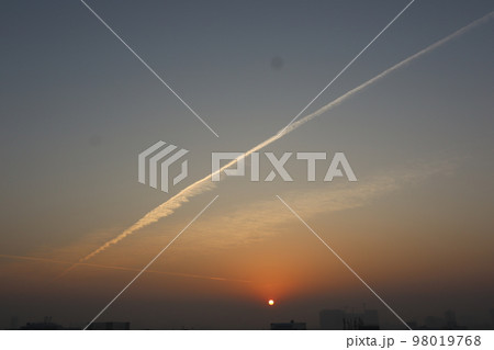 夕日と飛行機雲 98019768