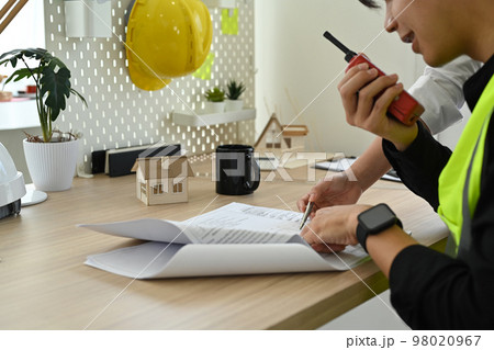 Architect team working together on design of a construction plan and examining construction plans at co working space Architect team working together on design of a construction plan and examining construction plans at co working space 98020967