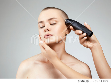 haircut of a beautiful girl. pretty woman cutting hair with hairclipper haircut of a beautiful girl. pretty woman cutting hair with hairclipper 98021409