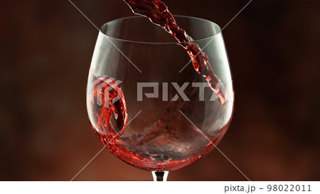 Pouring red wine into the glass, macro shot. 98022011