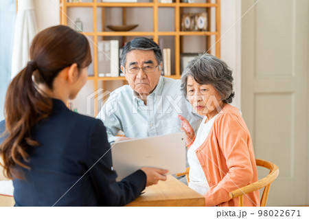 シニアの夫婦に営業をするビジネスウーマン 98022671