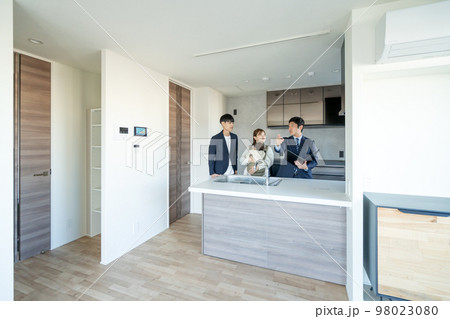 内覧　新築マンションのキッチンを見学する赤ちゃん連れの若い夫婦 98023080