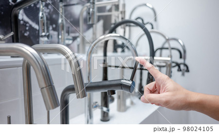 Male hand choosing water tap in furniture store 98024105