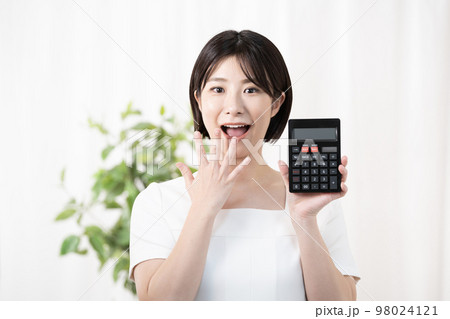 電卓を持って驚くエステテシャン 電卓を持って驚くエステテシャン 98024121