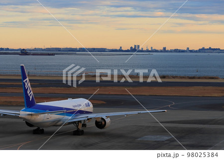朝焼けの空に出発する旅客機 羽田空港の早朝便 朝焼けの空に出発する旅客機 羽田空港の早朝便 98025384