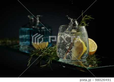 Gin tonic cocktail with lemon and rosemary. Gin tonic cocktail with lemon and rosemary. 98026491