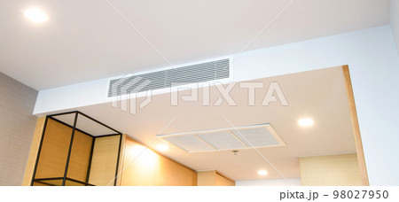 Ceiling mounted cassette type air conditioner and modern lamp light on white ceiling. duct air conditioner for home or office Ceiling mounted cassette type air conditioner and modern lamp light on white ceiling. duct air conditioner for home or office 98027950