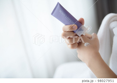 Close up of women applying body lotion cream on hand. 98027951
