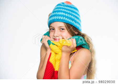 Kid wear warm soft knitted blue hat and long scarf. Warm woolen accessories. Hat and scarf keep warm. Which fabrics will keep you warmest this winter. Girl long hair happy face white background 98029030