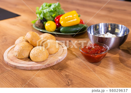 Freshly baked burger buns with sesame seeds in kitchen Freshly baked burger buns with sesame seeds in kitchen 98029637